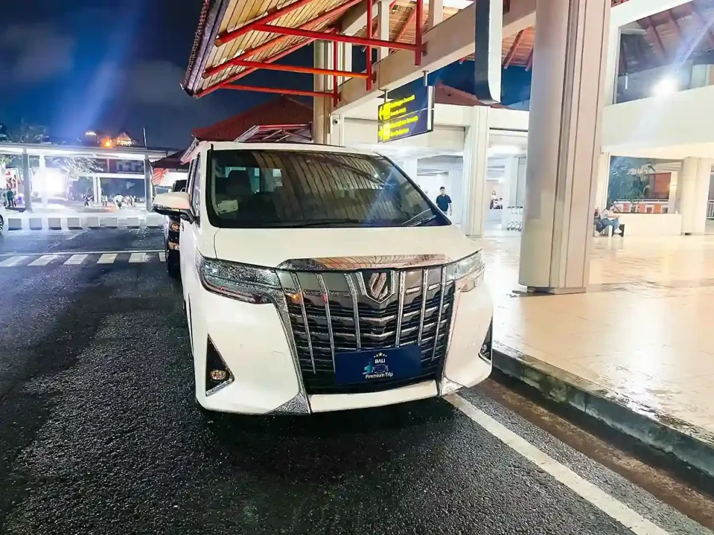 Toyota Alphard waiting at Bali airport curbside for a VIP night arrival pickup